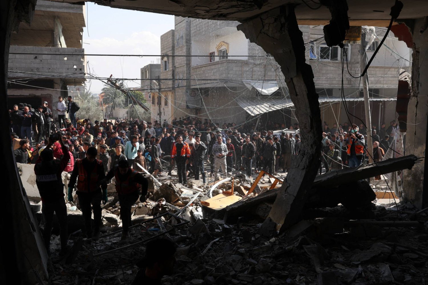فلسطينيون في موقع استهدفته غارة إسرائيلية في رفح جنوب قطاع غزة السبت (رويترز)