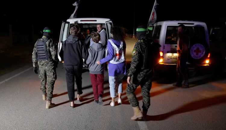 محتجزون إسرائيليون برفقة عناصر من كتائب القسام أثناء عملية تبادل مع أسرى فلسطينيين - رويترز.