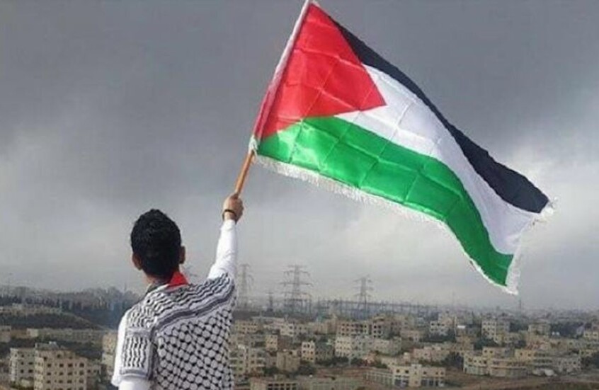 شاب فلسطيني يرفع علم بلاده في وجه قوات الجيش الإسرائيلي