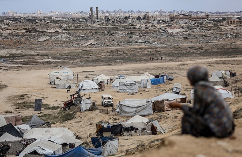 سيدة فلسطينية تجلس على تلة في دير البلح بعد نزوحها جراء العمليات العسكرية الإسرائيلية في قطاع غزة - 6 أكتوبر 2025. / Gettyimages.ru