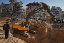 فلسطينيون يراقبون آليات مصرية تبحث عن جثث أسرى إسرائيليين في مدينة حمد بمدينة خان يونس جنوب قطاع غزة. / Globallookpress