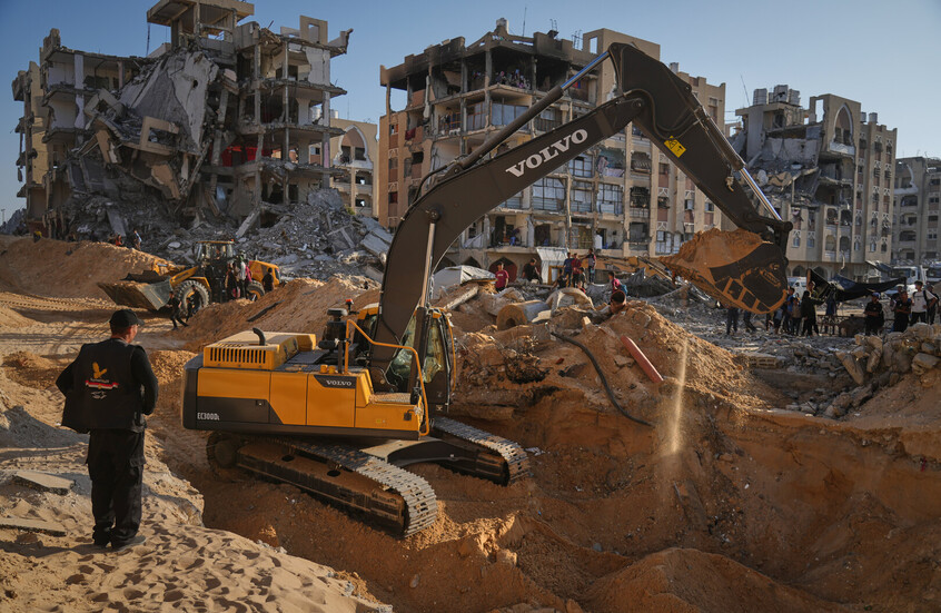 فلسطينيون يراقبون آليات مصرية تبحث عن جثث أسرى إسرائيليين في مدينة حمد بمدينة خان يونس جنوب قطاع غزة. / Globallookpress