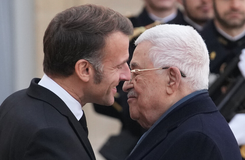الرئيس الفرنسي إيمانويل ماكرون (يسار) يعانق الرئيس الفلسطيني محمود عباس قبل محادثاتهما اليوم الثلاثاء في قصر الإليزيه في باريس. / AP