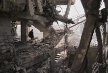 فلسطينيون يتفقدون الأنقاض بعد يوم من غارة إسرائيلية على مبنى في مدينة غزة (الخميس 20 نوفمبر). / AP