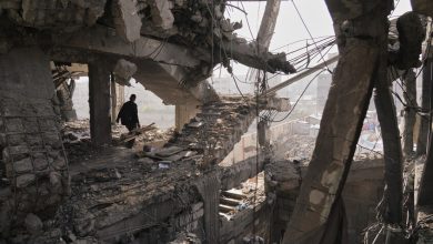 فلسطينيون يتفقدون الأنقاض بعد يوم من غارة إسرائيلية على مبنى في مدينة غزة (الخميس 20 نوفمبر). / AP