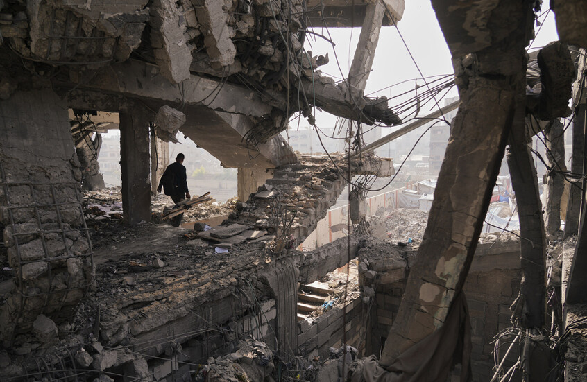 فلسطينيون يتفقدون الأنقاض بعد يوم من غارة إسرائيلية على مبنى في مدينة غزة (الخميس 20 نوفمبر). / AP