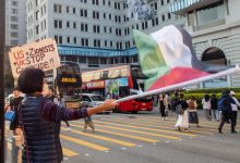 ناشطة تحمل علم فلسطين ولافتة خلال احتجاج يطالب الولايات المتحدة والحركة الصهيونية والمملكة المتحدة بوقف الإبادة الجماعية في شارع سالزبوري في هونغ كونغ. / Globallookpress