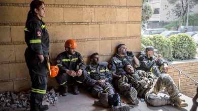 عمال إنقاذ لبنانيون في يستريحون في أحد المواقع بعد العمل في مكان استهدفته غارة إسرائيلية / Globallookpress