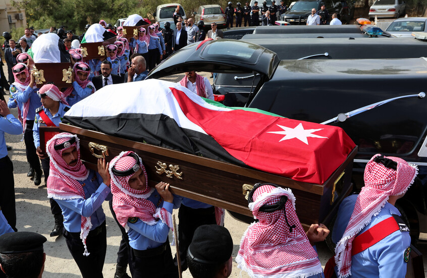 يحمل أفراد من الحرس الشرفي الأردني توابيت مغطاة بالأعلام لضحايا قُتلوا في هجوم على كنيسة أرثوذكسية يونانية، خلال موكب جنازتهم في الكرك، الأردن / AP